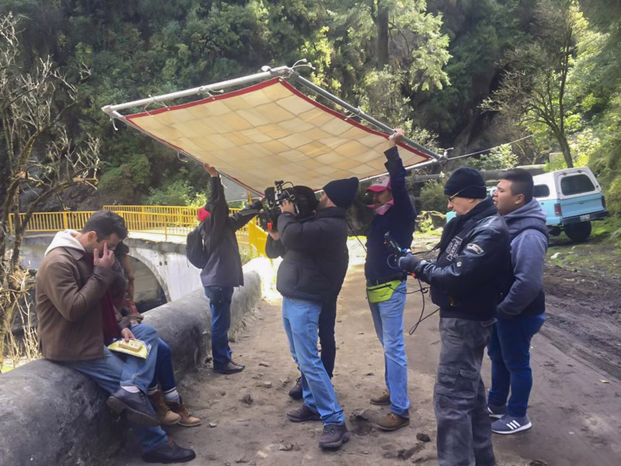 Making of — equipo sosteniendo un difusor en el bosque